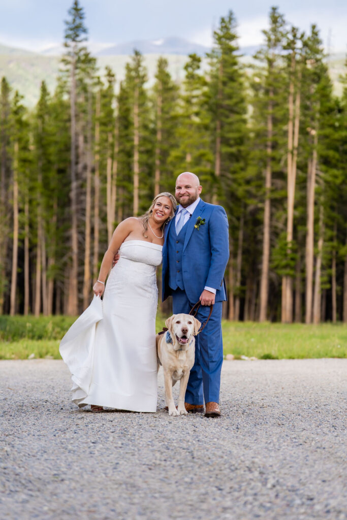 Bride and groom posing with their dog after their Colorado mountain elopement ceremony.