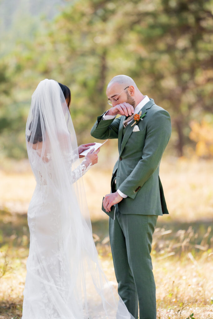 Bride reading vows to emotional groom during an intimate Colorado elopement with fall colors in the background