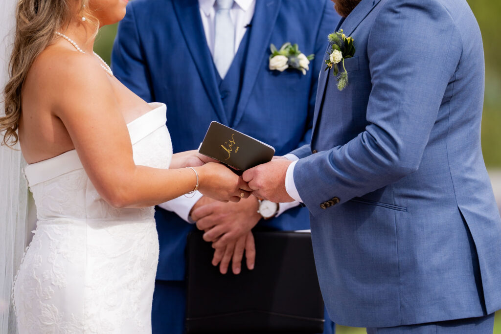 Bride and groom exchanging vows during an intimate outdoor elopement ceremony with an officiant.