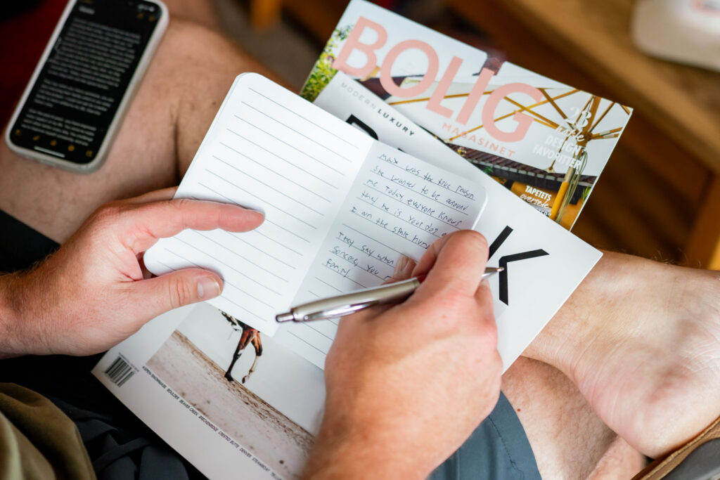 Bride or groom writing personal wedding vows in a notebook during a quiet morning before their elopement ceremony.
