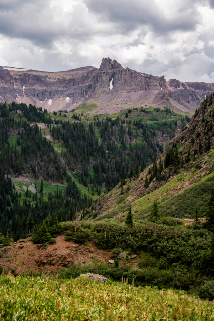 Drone view of Yankee Boy Basin showcasing dramatic alpine peaks and lush mountain valleys in Colorado's San Juan Mountains.
